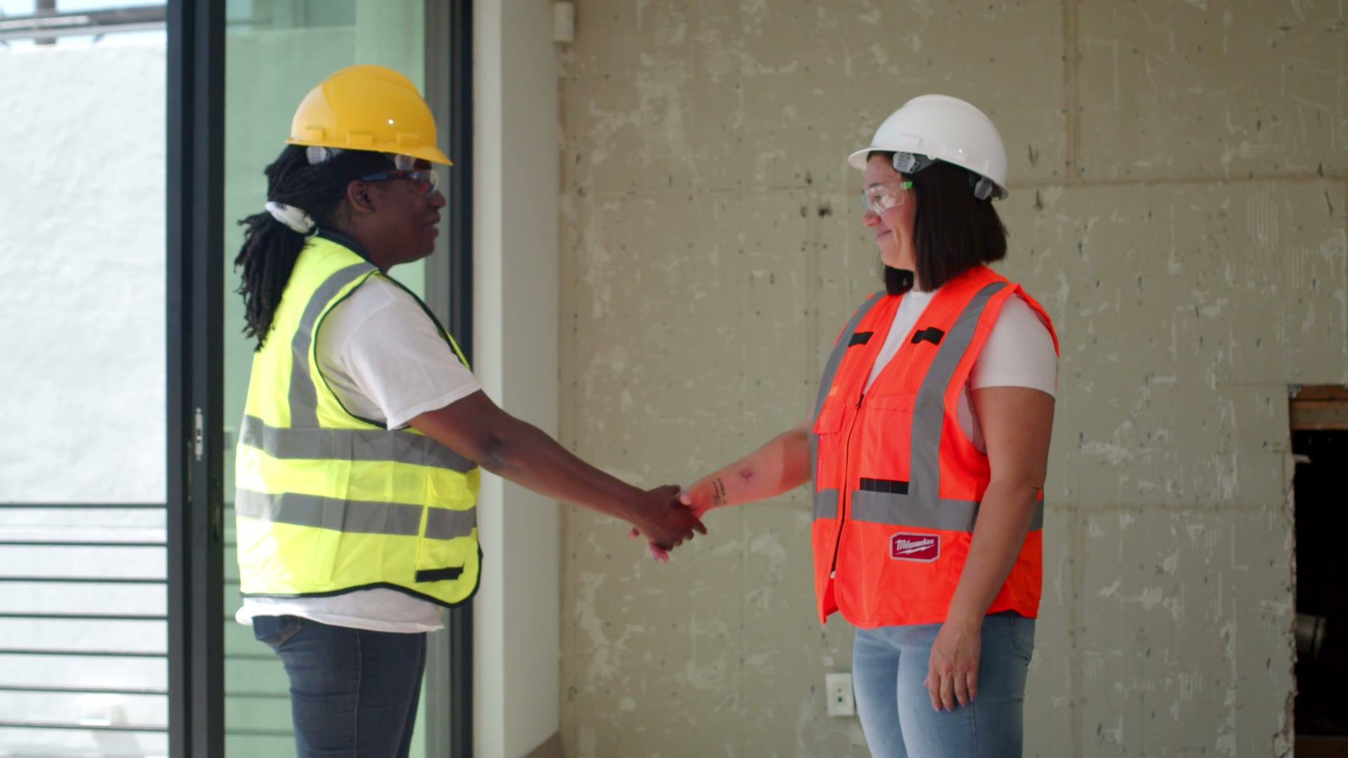 Two engineers in hard hats shaking hands